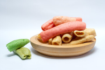 Colorful traditional crackers stacked in a wooden bowl with red, green, and yellow tones, symbolizing Asian street food culture, crunchy snack, and popular appetizer for everyday meals.