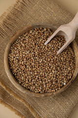 Raw buckwheat porridge in neutral beige background copy space. Whole spelt grain species. High protein fiber-rich vegan plant based food ingredient. Gluten free superfood healthy nutritional dietary