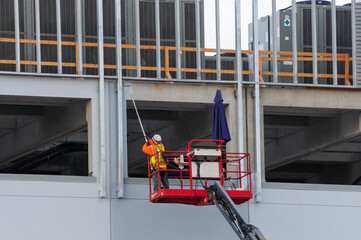 A construction worker operates a boom lift to paint the exterior structure of a data center building, part of ongoing infrastructure development in a designated technology and industrial zone © Eduardo Barraza