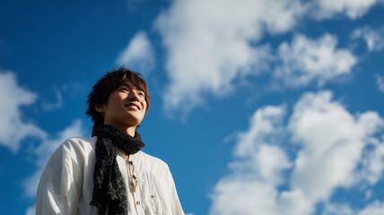 男性が青空を見上げて立つ