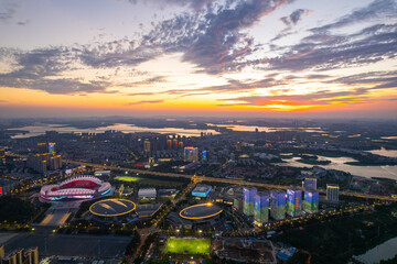 Wuhan china city skyline shows buildings and stadium at sunset.