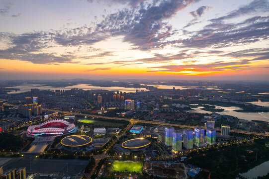 Wuhan china city skyline shows buildings and stadium at sunset.