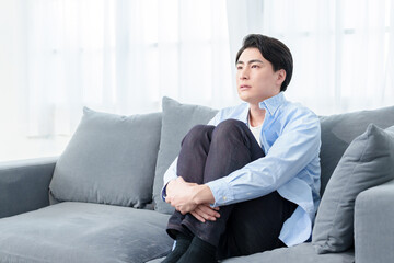 ソファでうずくまる男性