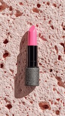 Pink lipstick on textured pink surface, sunlight