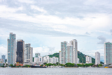 A vibrant skyline in Cartagena, Colombia showcasing contemporary buildings amidst lush hills and coastal views.