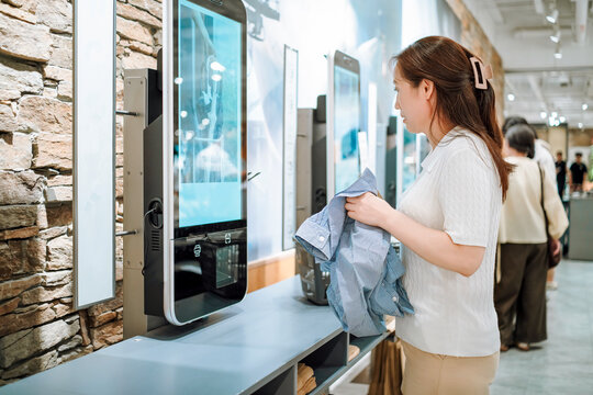 Woman using smart mirror technology in modern store
