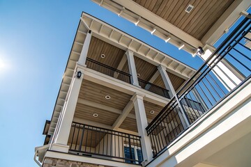 Stunning Low-Angle View of a Two-Story Home's Exterior with Elegant Balconies and Wooden Ceilings
