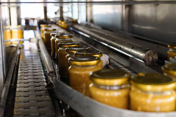 Mustard production line showcasing glass jars being filled and packed in a manufacturing facility