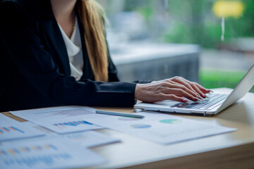 Business colleagues analyzing documents and charts at an office desk, focusing on planning, teamwork, financial analysis, cooperation, and decision-making.
