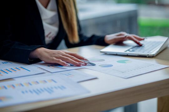 Business colleagues analyzing documents and charts at an office desk, focusing on planning, teamwork, financial analysis, cooperation, and decision-making.