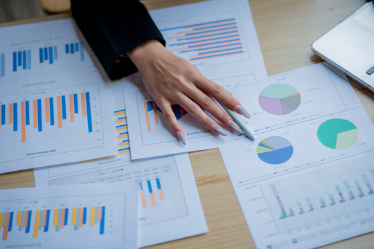 Business colleagues analyzing documents and charts at an office desk, focusing on planning, teamwork, financial analysis, cooperation, and decision-making. - Powered by Adobe