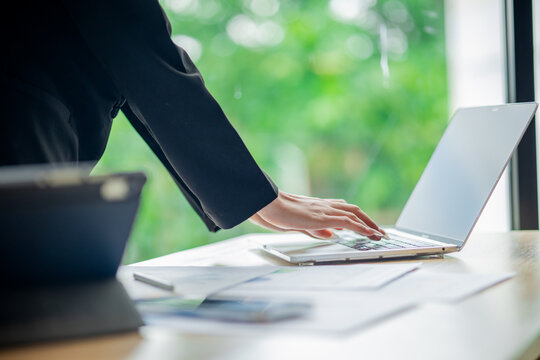 Business colleagues analyzing documents and charts at an office desk, focusing on planning, teamwork, financial analysis, cooperation, and decision-making.