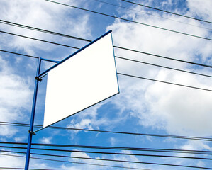 Blank advertisement board on blue sky with messy power cords 