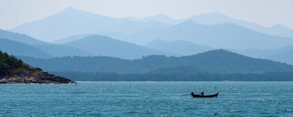 Obraz premium Boat on Calm Water with Distant Mountains