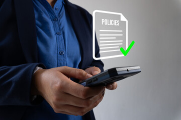 Business policy review. Close-up of a businessman's hands holding a cell phone over an icon of a document with the word 