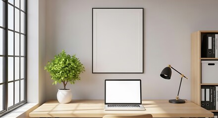 Fototapeta premium Bright workspace featuring a laptop, plant, and lamp on a wooden desk with a blank framed picture hanging above.