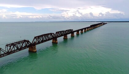 Obraz premium Aerial view of a rusty bridge over teal water