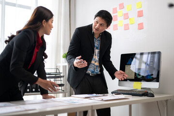 Business people discussing charts and graphs on computer screen