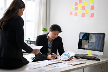 Business people analyzing charts and graphs on desk in office