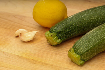 Garlic, Lemon, and Zucchini on Wooden Cutting Board