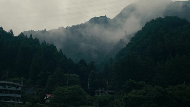 Traditional Japanese village set in misty Oku Tama mountain valley with lush greenery &ndash; Scenic cinematic shot.