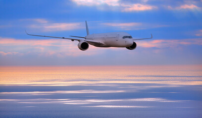 Airplane flying over tropical sea at sunset