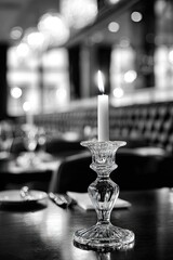Lit candle on crystal candlestick on restaurant table