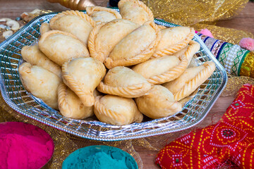 Gujhiya, Indian fried sweet with dry fruits and fancy decorative background