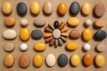 A collection of smooth, colorful stones arranged in a circular pattern on a woven mat, representing balance and natural harmony