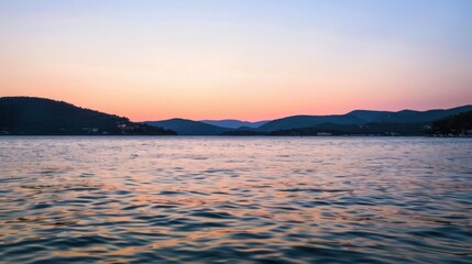 Fototapeta premium Sunset Reflection on a Calm Lake with Distant Hills