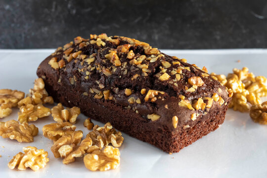 Brownie loaf garnished with walnut on white top
