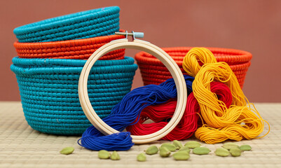 Vibrant Cultural Still Life: Handwoven Baskets and Embroidery Hoop on a Mat