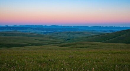 Sunrise over rolling hills, grassy plains, mountain range