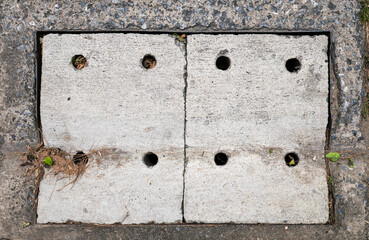 Old Rectangular Urban Drain Cover Made of Metal Grate and Concrete.