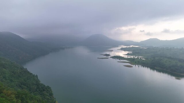 lake serene blue water with misty mountains aerial image is taken at umiam lake shillong meghalaya india. it is showing the breathtaking beauty of nature.