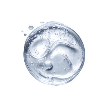 Close-up shot of a single white round drop of textured serum on a smooth surface
