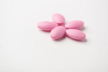 Multivitamin tablets on bright paper background. Close up. Copy space	