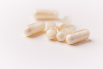 Coenzyme Q10 capsules. Antioxidants. Concept for a healthy dietary supplementation. Bright paper background. Soft focus. Close up. Copy space.	