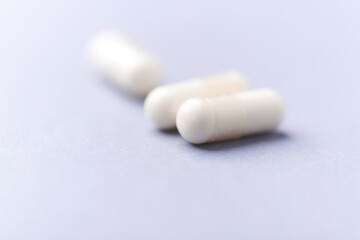 Creatine capsules on paper background. Soft focus. Close up. Copy space.	