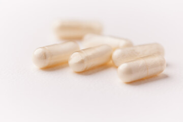 Coenzyme Q10 capsules. Antioxidants. Concept for a healthy dietary supplementation. Bright paper background. Soft focus. Close up. Copy space.	