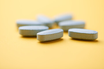 Multivitamin tablets on bright paper background. Close up. Copy space	