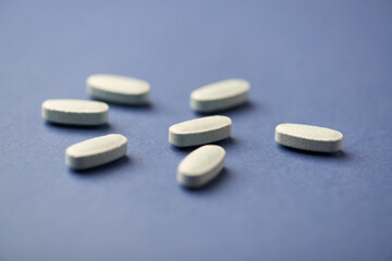 Multivitamin tablets on dark paper background. Soft focus. Close up. Copy space	