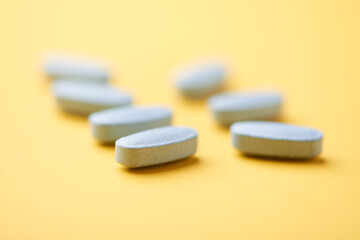 Multivitamin tablets on bright paper background. Close up. Copy space	