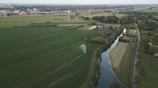 Water sprayer on agricultural fields near township of Breukelen , aerial view