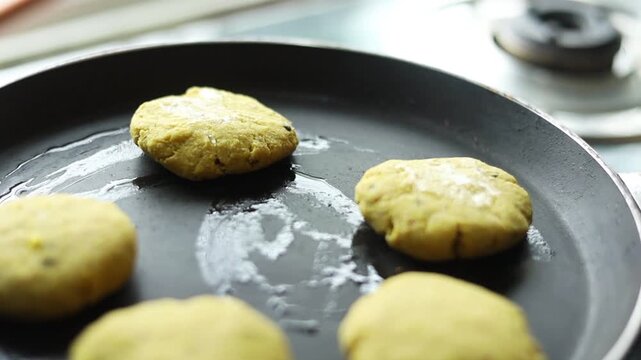 Tikki an indian street food being fried in oil on a pan