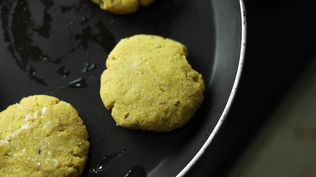 Tikki an indian street food being fried in oil on a pan