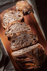 cranberry walnuts sourdough bread sliced placed on wooden cutting board.