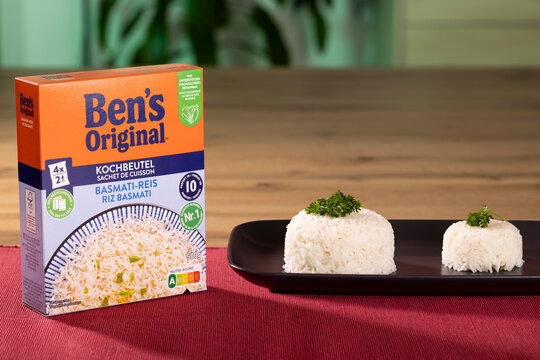 Ben&rsquo;s Original basmati rice 500g package with freshly cooked rice served on a black plate and garnished with parsley.