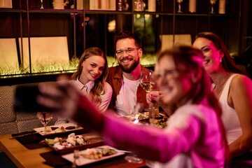 Friends Gather to Share a Meal and Capture Memories in a Cozy Restaurant