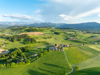 Aerial view of rural landscape in Swiss canton of Fribourg. Hills and forests in evening sunlight in district of Sense.